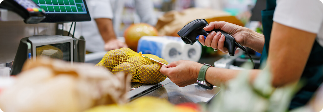 a cashier scans the price on a bag of potatoes